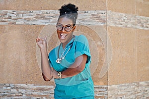 African american doctor female at lab coat with stethoscope posed outdoor against clinic