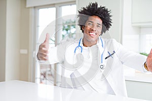 African American doctor man at the clinic looking at the camera smiling with open arms for hug