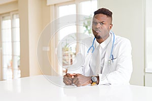 African american doctor man at the clinic skeptic and nervous, frowning upset because of problem