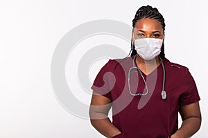 African american doctor in a medical mask over white background with copy space. Medicine, healthcare and people concept