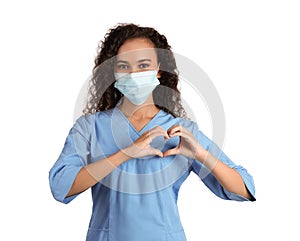 African-American doctor in protective mask making heart with hands on white background