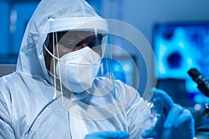 African-american doctor in protective suit is doing a science experiments and developing vaccine in a modern lab