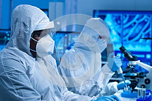 African-american doctor in protective suit is doing a science experiments and developing vaccine in a modern lab