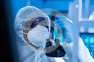 African-american doctor in protective suit is doing a science experiments and developing vaccine in a modern lab