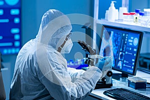 African-american doctor in protective suit is doing a science experiments and developing vaccine in a modern lab