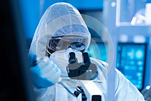 African-american doctor in protective suit is doing a science experiments and developing vaccine in a modern lab