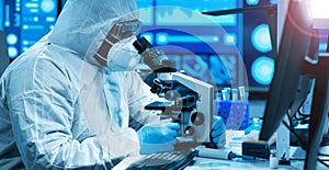 African-american doctor in protective suit is doing a science experiments and developing vaccine in a modern lab