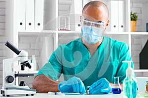 African american doctor sitting at the table and preparing to do an injection of a drug