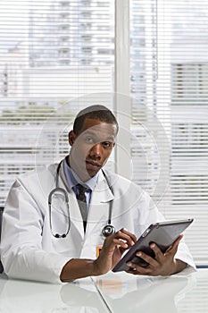 African American doctor using electronic tablet, vertical