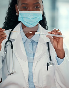 African american doctor wearing a covid mask. Young doctor holding a sterile swab stick. medical professional holding a