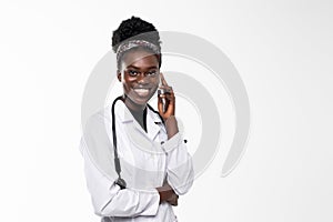 African american doctor woman, medical professional working happy talking using a smartphone mobile phone isolated on white