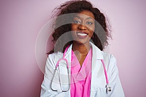 African american doctor woman wearing stethoscope over isolated pink background happy face smiling with crossed arms looking at