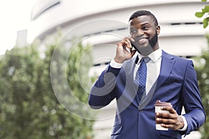 African American employee talking on mobile phone having coffee break