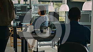 African american it engineer writing code on laptop and computer