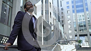 African american entrepreneur standing on stairs near office building, prospects