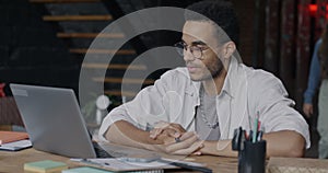 African American entrepreneur talking during online video call concentrated on virtual meeting in loft style office