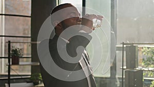 African American ethnic mature businessman senior man entrepreneur drink water glass of pure liquid in hot sun shining