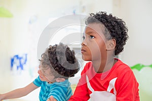 African American ethnicity kid with moody emotion sitting in classroom in kindergarten ,education concept