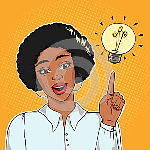 African american excited businesswoman pointing on lightning bulb, idea concept vector illustration in pop art style eps10