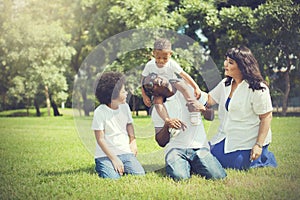 African American family alongside with Asian mum being playful and having good times in the park