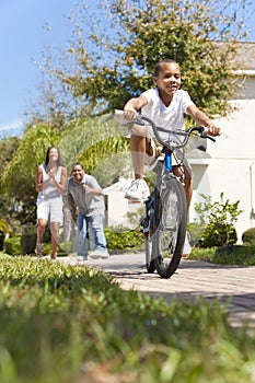 African American Family Boy Riding Bike & Parents
