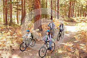 African American Family Cycling Through Fall Woodland