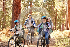 African American Family Cycling Through Fall Woodland photo