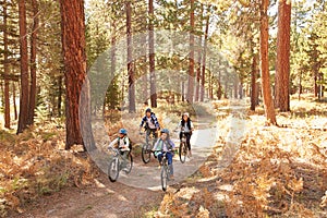 African American Family Cycling Through Fall Woodland