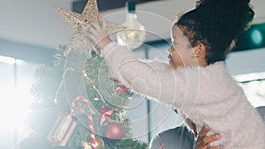 African American family decorated with ornament on Christmas tree at Christmas and New Year festival at home. Xmas celebration