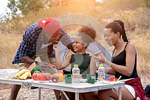 African american family  eating food during picnic