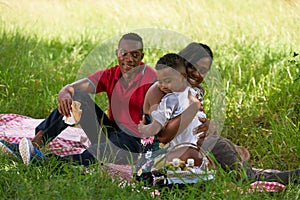 African American Family With Father Mother Child Hugging In Park