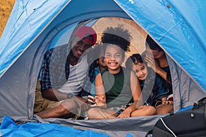 African american family, parent with kids, and asian adoped child having fun together in camping at natural park