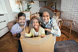 African American family, parents and daughter, unpacking boxes and moving into a new home