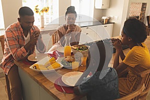 African American family praying together at dining table