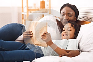 African american family reading book in bedroom