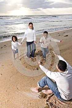 African-American family running to dad on beach