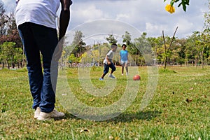 African American family with son and daughter playing a soccer together on the field for relaxation