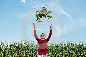 African American farmer throws corn cobs up.