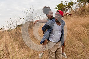 African american father and daughter having fun playing piggyback together during traveling countryside