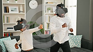 African american father and daughter playing video game using virtual reality glasses at home