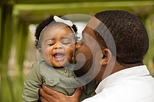 African American father holding his daughter.