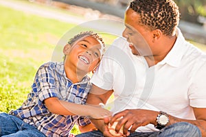 African American Father and Mixed Race Son Playing with Baseball in the Park