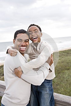 African-American father and son laughing at beach