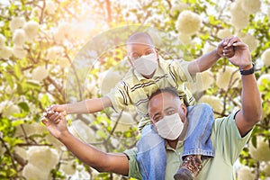 African American Father And Son Playing Outdoors Wearing Medical Face Mask