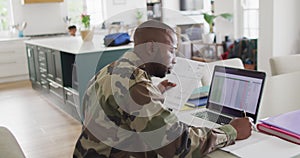 African american father with son sitting at table and working