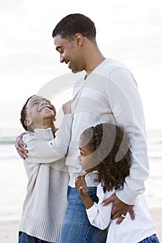 African-American father and two children on beach