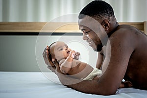 African American father used both hands to support his daughter`s head, 3 mount-old baby newborn