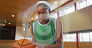 African american female basketball player dribbling and shooting with ball