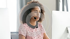 African American female call center operator in headset using computer
