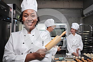 African American female chef looks at camera with a cheerful smile in a kitchen